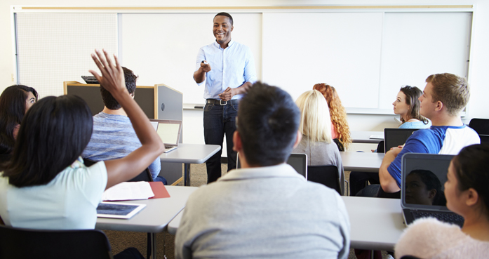 Male Tutor Teaching University Students In Classroom
